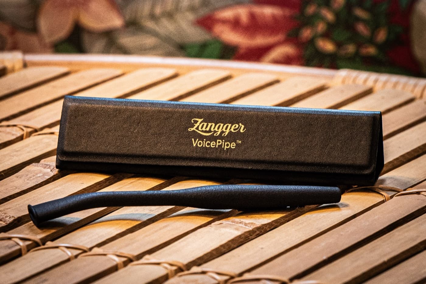 The Zangger VoicePipe and its gold-stamped case on a bamboo table